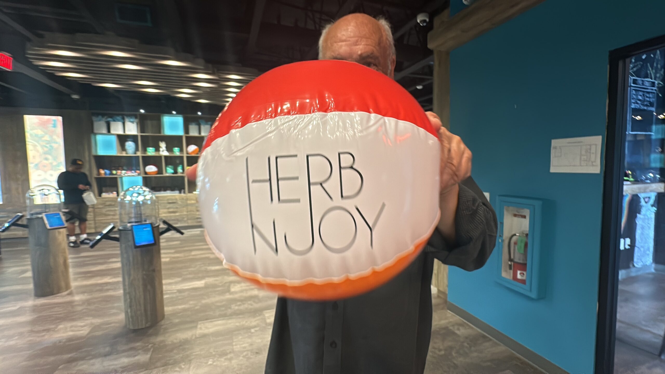 A man holding a HerbNJoy beach ball