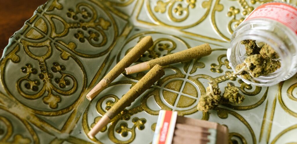 A few infused prerolls on a white and gold tray